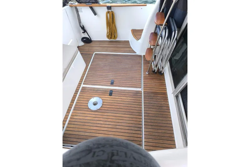  Yacht Photos Pics 2009 Jeanneau Merry Fischer 925 boat deck with wooden flooring and folding chairs.