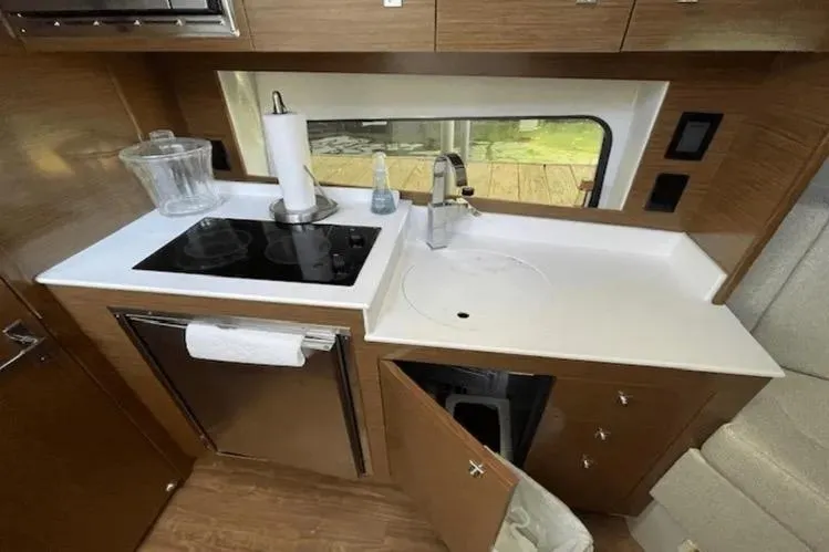  Yacht Photos Pics 2018 Cruisers Yachts 390 Express Coupe kitchen with stove, sink, and storage.