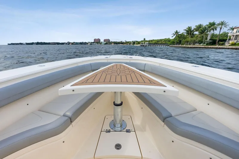 Prime Tyme Yacht Photos Pics 2020 Scout 355 LXF boat interior with seating and table, overlooking calm waters.