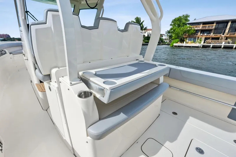 Prime Tyme Yacht Photos Pics 2020 Scout 355 LXF boat interior with seating and cup holders on a sunny day.