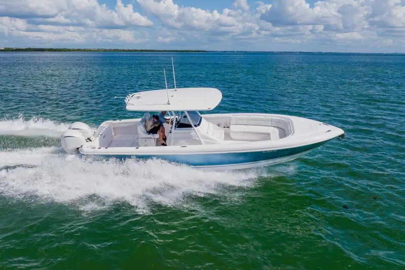  Yacht Photos Pics 2018 Intrepid 327 Center Console boat cruising on open water under a clear sky.