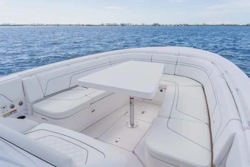 Yacht Photos Pics 2018 Intrepid 327 Center Console boat with white seating and table on open water.