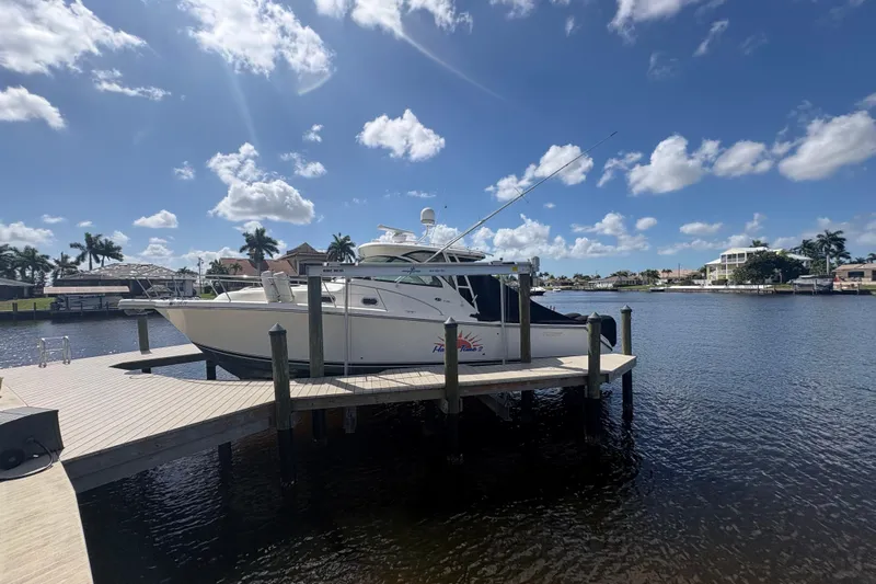 Happy Time 2 Yacht Photos Pics 2011 Pursuit OS 375 Offshore boat docked on a sunny waterfront with palm trees.