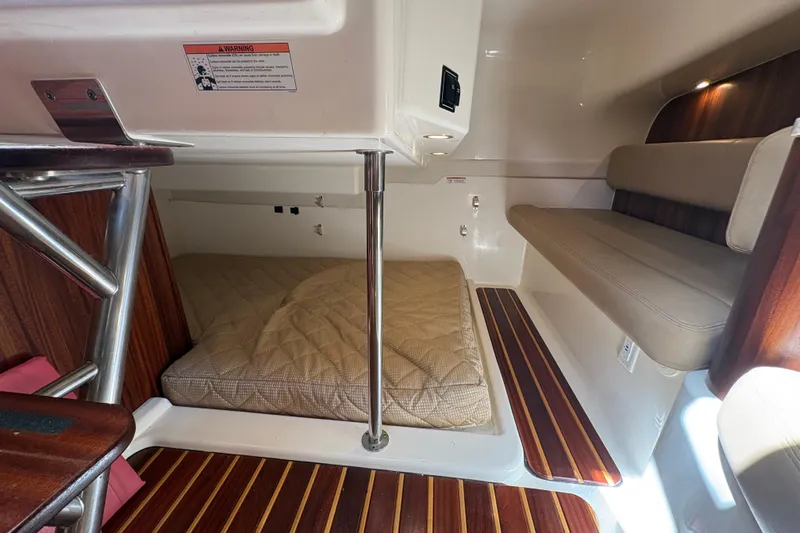 Happy Time 2 Yacht Photos Pics 2011 Pursuit OS 375 Offshore cabin interior with wood accents and cushioned seating.