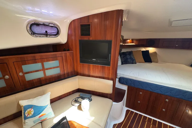 Happy Time 2 Yacht Photos Pics Luxurious interior of 2011 Pursuit OS 375 Offshore boat with wood finish and cozy seating.