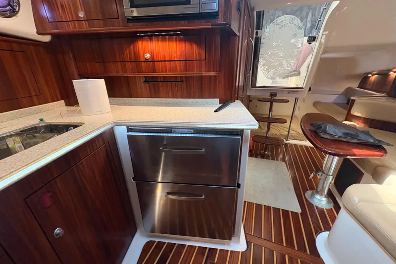 Happy Time 2 Yacht Photos Pics Interior of a 2011 Pursuit OS 375 Offshore boat with wood cabinetry and stainless steel appliances.
