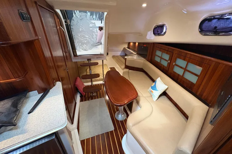 Happy Time 2 Yacht Photos Pics Luxurious interior of 2011 Pursuit OS 375 Offshore boat with wood accents and seating.