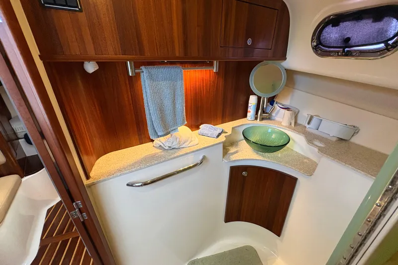 Happy Time 2 Yacht Photos Pics 2011 Pursuit OS 375 Offshore bathroom with wooden cabinetry and glass sink.