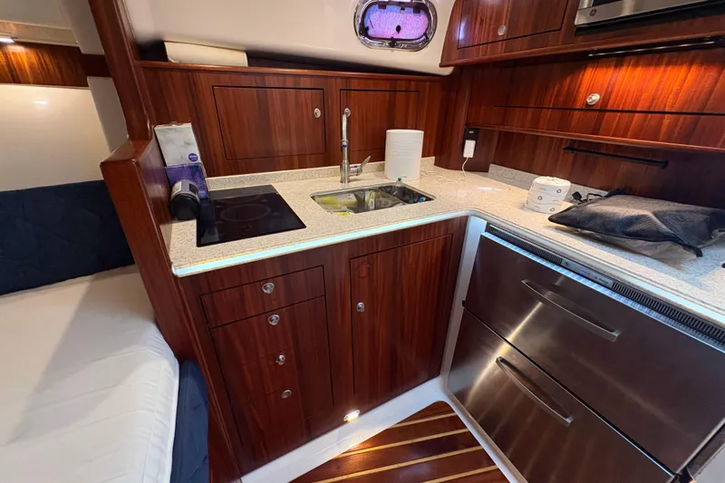 Happy Time 2 Yacht Photos Pics Luxurious 2011 Pursuit OS 375 Offshore yacht kitchen with wood cabinetry and modern appliances.