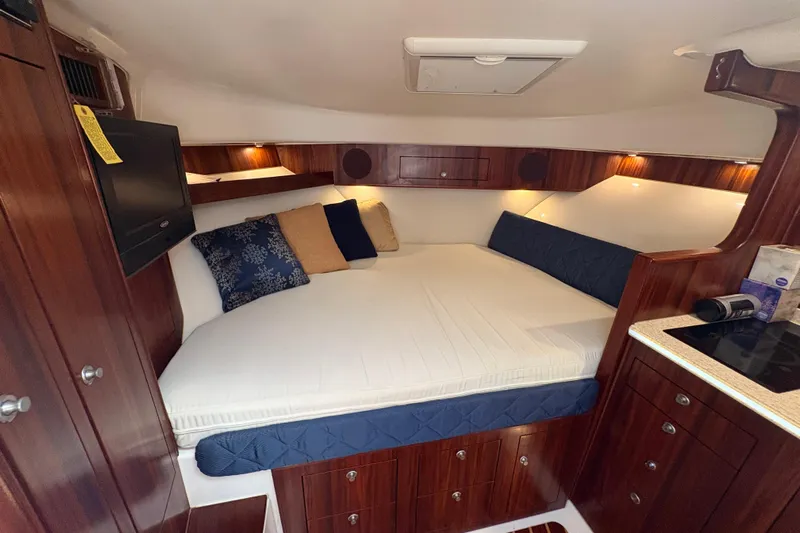 Happy Time 2 Yacht Photos Pics Luxurious cabin interior of 2011 Pursuit OS 375 Offshore boat with cozy bedding.