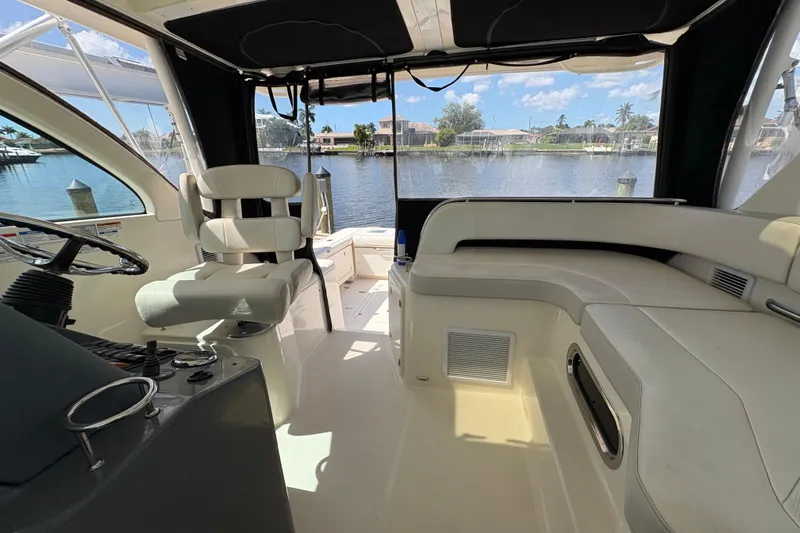 Happy Time 2 Yacht Photos Pics Interior of 2011 Pursuit OS 375 Offshore boat with seating and steering wheel, overlooking water.