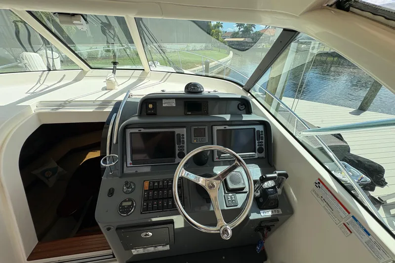 Happy Time 2 Yacht Photos Pics Helm of 2011 Pursuit OS 375 Offshore boat with navigation equipment and steering wheel.