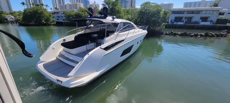  Yacht Photos Pics Azimut Atlantis 44 yacht, 2013 model, cruising on a calm waterway with lush greenery.