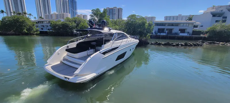  Yacht Photos Pics Azimut Atlantis 44 yacht, 2013 model, cruising in a serene waterway with urban backdrop.