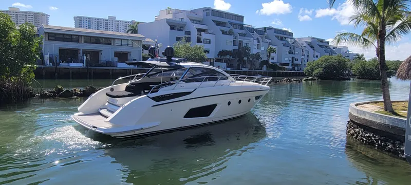  Yacht Photos Pics 2013 Azimut Atlantis 44 yacht cruising in a scenic canal with modern buildings.