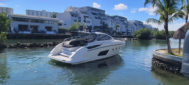  Yacht Photos Pics 2013 Azimut Atlantis 44 yacht cruising in a scenic canal with modern buildings.