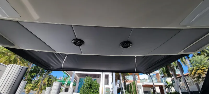  Yacht Photos Pics 2013 Azimut Atlantis 44 boat canopy with speakers, docked near modern buildings and palm trees.