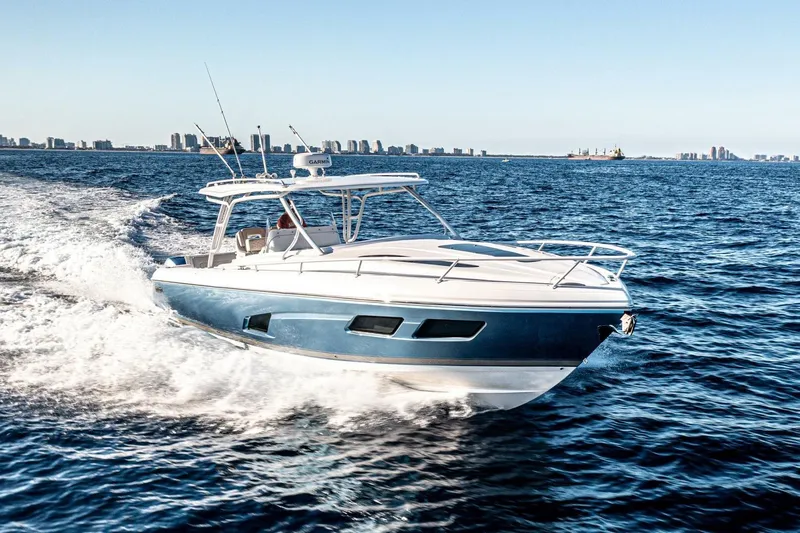  Yacht Photos Pics 2022 Intrepid 409 Valor cruising on open water with city skyline in background.