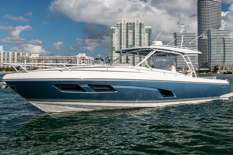  Yacht Photos Pics 2022 Intrepid 409 Valor boat on water with city skyline background.