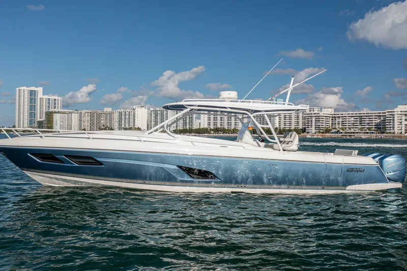  Yacht Photos Pics 2022 Intrepid 409 Valor boat cruising near city skyline on a sunny day.