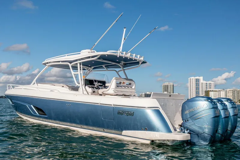  Yacht Photos Pics 2022 Intrepid 409 Valor boat with triple Mercury engines on water, city skyline background.