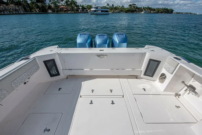  Yacht Photos Pics 2022 Intrepid 409 Valor boat deck with triple outboard engines on calm water.