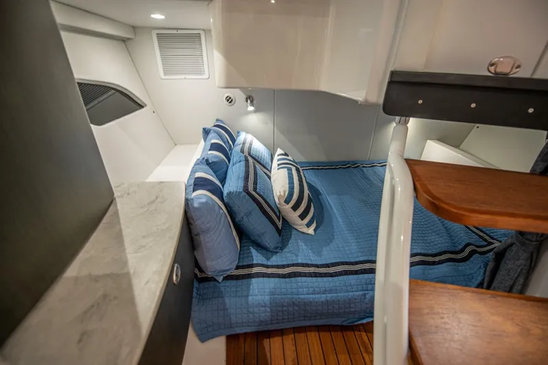  Yacht Photos Pics 2022 Intrepid 409 Valor cabin with blue bedding and wooden flooring.