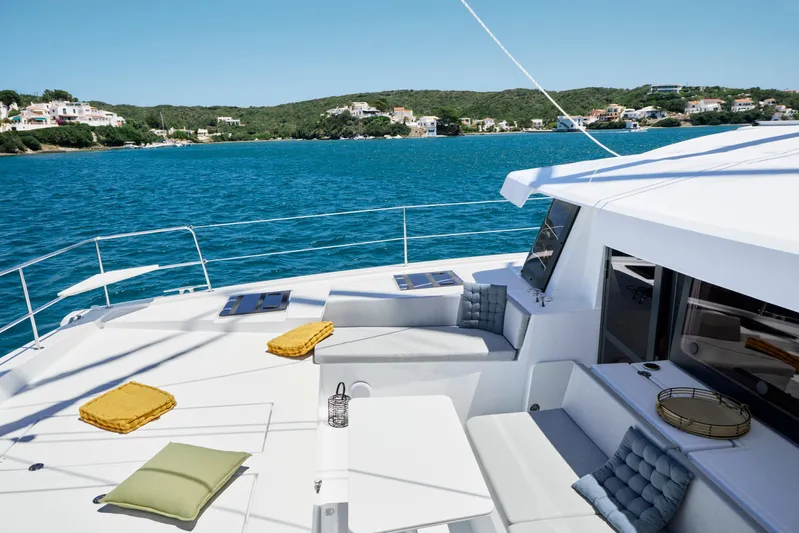  Yacht Photos Pics Luxurious Bali 4.4 yacht deck with cushions, overlooking serene blue waters and coastal homes.