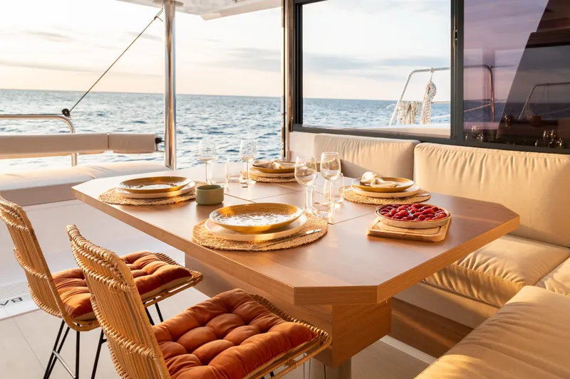 Yacht Photos Pics Luxurious dining setup on Bali 4.4 yacht, 2026 model, with ocean view at sunset.