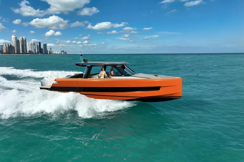  Yacht Photos Pics 2026 Fjord 490 OPEN cruising on ocean near city skyline under blue sky.