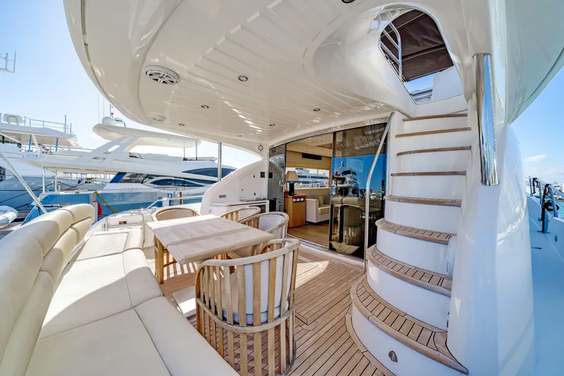 Twins Yacht Photos Pics Luxurious 2009 Sunseeker Manhattan 70 yacht with elegant outdoor seating and staircase.