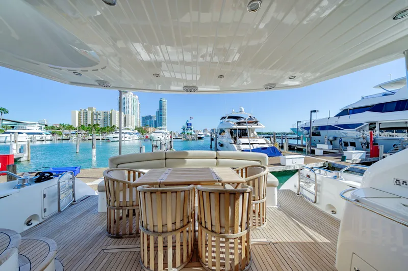 Twins Yacht Photos Pics Luxurious 2009 Sunseeker Manhattan 70 yacht with elegant outdoor seating at a marina.