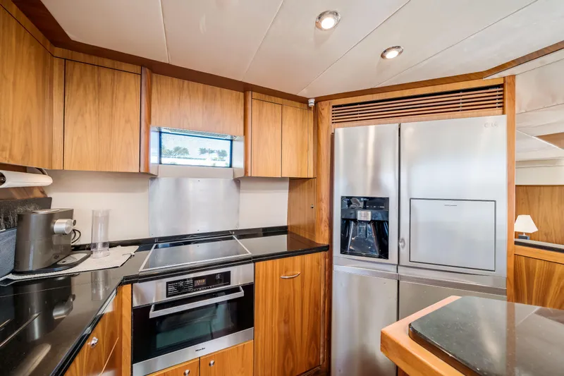 Twins Yacht Photos Pics Luxurious kitchen in 2009 Sunseeker Manhattan 70 yacht with modern appliances and wood cabinetry.