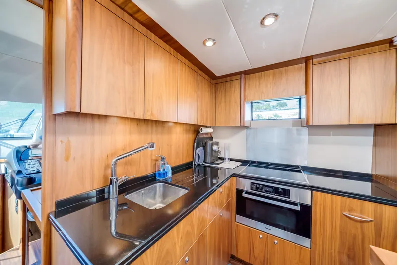 Twins Yacht Photos Pics Luxurious kitchen in 2009 Sunseeker Manhattan 70 yacht with modern appliances and wood cabinetry.