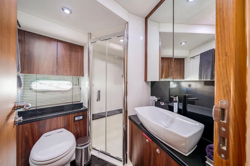 Twins Yacht Photos Pics Luxurious bathroom in 2009 Sunseeker Manhattan 70 yacht with modern fixtures and wood accents.