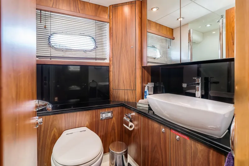 Twins Yacht Photos Pics Luxurious bathroom in 2009 Sunseeker Manhattan 70 yacht with wood paneling and modern fixtures.