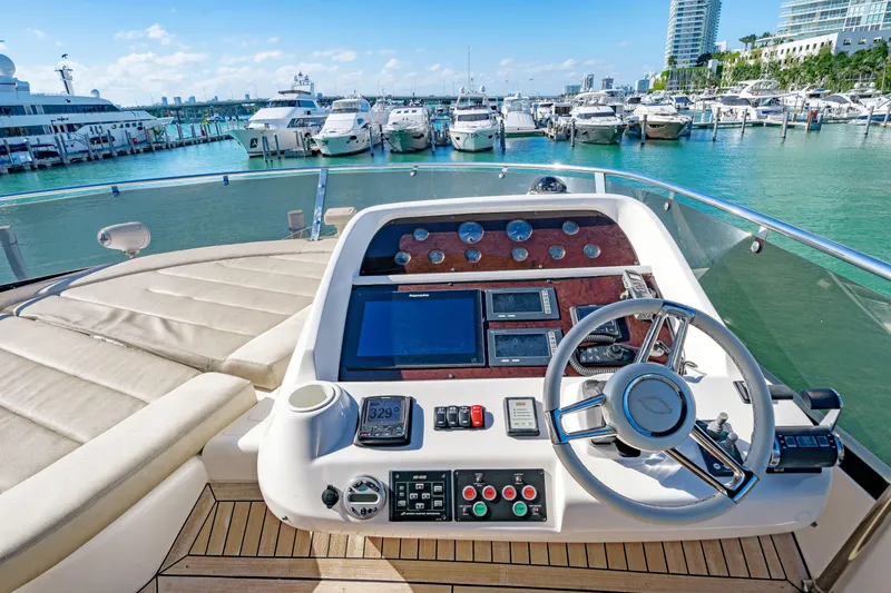Twins Yacht Photos Pics 2009 Sunseeker Manhattan 70 yacht helm with marina view, featuring modern navigation controls.