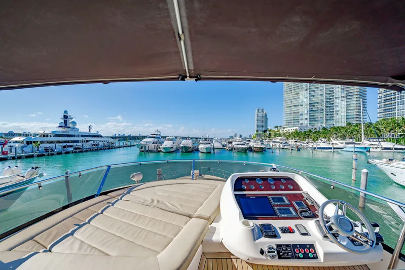 Twins Yacht Photos Pics Sunseeker Manhattan 70 yacht helm view, overlooking marina with luxury boats and city skyline, 2009 model.