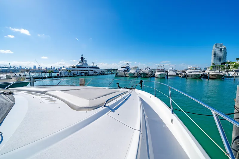 Twins Yacht Photos Pics Sunseeker Manhattan 70 yacht, 2009 model, docked in a marina under clear blue skies.