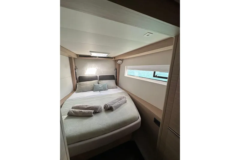  Yacht Photos Pics Luxurious cabin interior of 2024 Lagoon 51 yacht with cozy bedding and natural light.