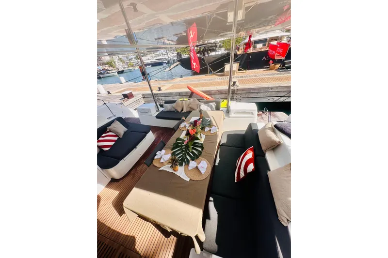  Yacht Photos Pics Luxurious 2024 Lagoon 51 yacht deck with elegant seating and decorative table setting.