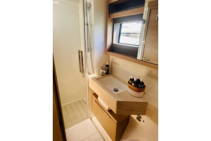  Yacht Photos Pics Modern bathroom in 2024 Lagoon 51 yacht with sleek sink and shower.
