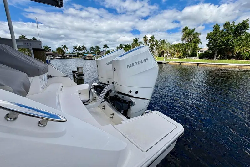 Liquid Asset Yacht Photos Pics 2024 Tiara Yachts 34 LX with Mercury outboard engines docked by a scenic waterfront.