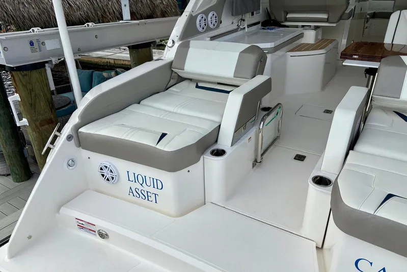 Liquid Asset Yacht Photos Pics 2024 Tiara Yachts 34 LX interior with "Liquid Asset" text, featuring luxurious seating.