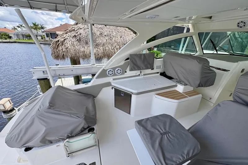 Liquid Asset Yacht Photos Pics 2024 Tiara Yachts 34 LX interior with covered seating and modern amenities by the water.