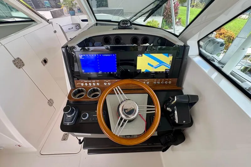 Liquid Asset Yacht Photos Pics 2024 Tiara Yachts 34 LX helm with modern navigation system and wooden steering wheel.