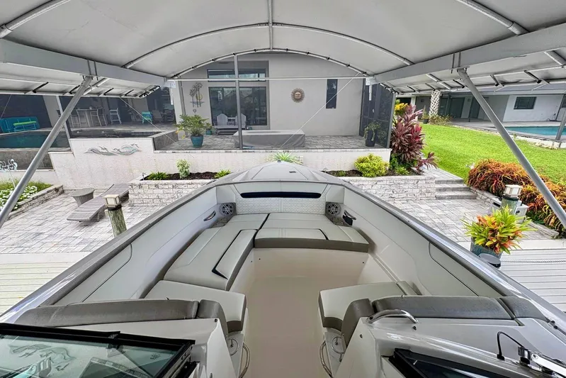 Liquid Asset Yacht Photos Pics 2024 Tiara Yachts 34 LX boat under canopy, docked near modern home with garden.