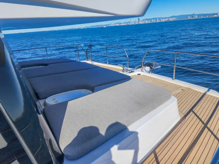  Yacht Photos Pics Luxurious Sunpower 44 VIP yacht deck with sunbeds, overlooking the ocean and city skyline, 2022 model.