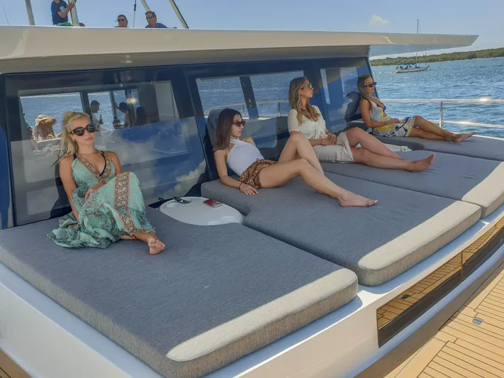  Yacht Photos Pics Women relaxing on Sunpower 44 VIP yacht, 2022 model, enjoying sunny weather and ocean views.