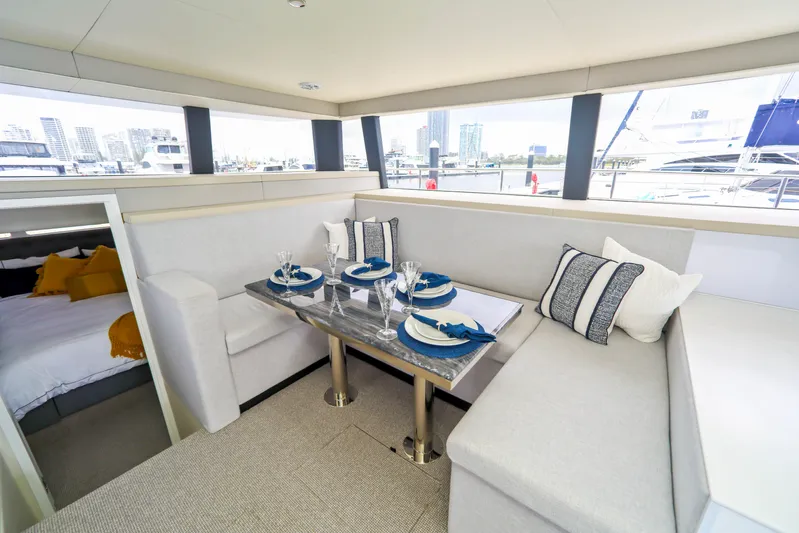  Yacht Photos Pics Luxurious Sunpower 44 VIP yacht interior with elegant dining area, modern decor, and cityscape view.